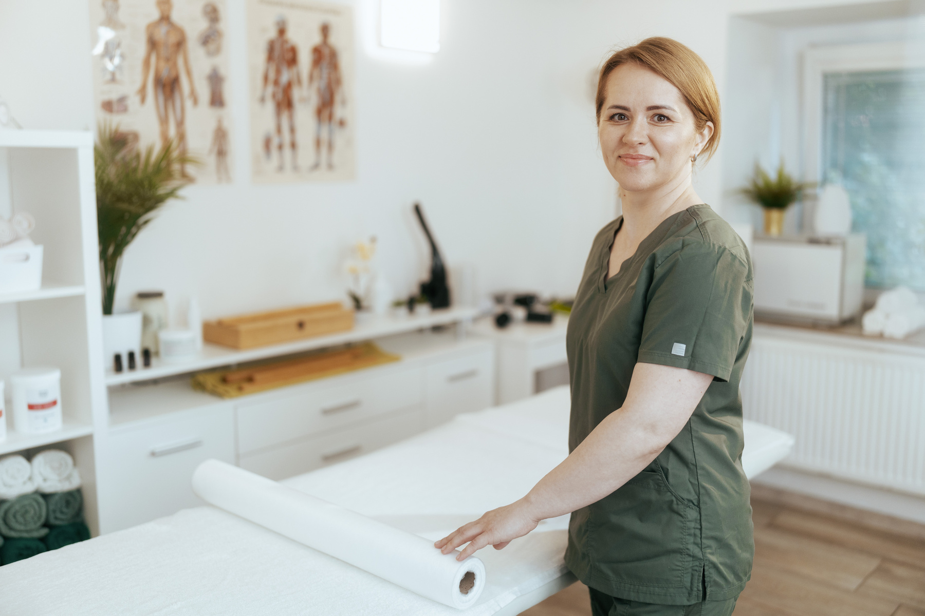 happy massage therapist woman in massage cabinet